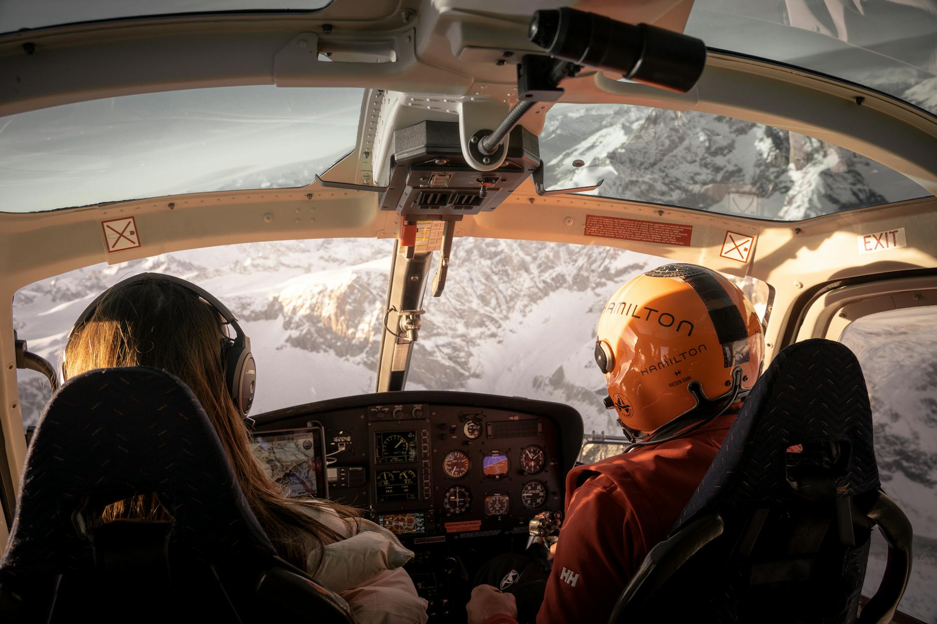 people flying in helicopter over mountains