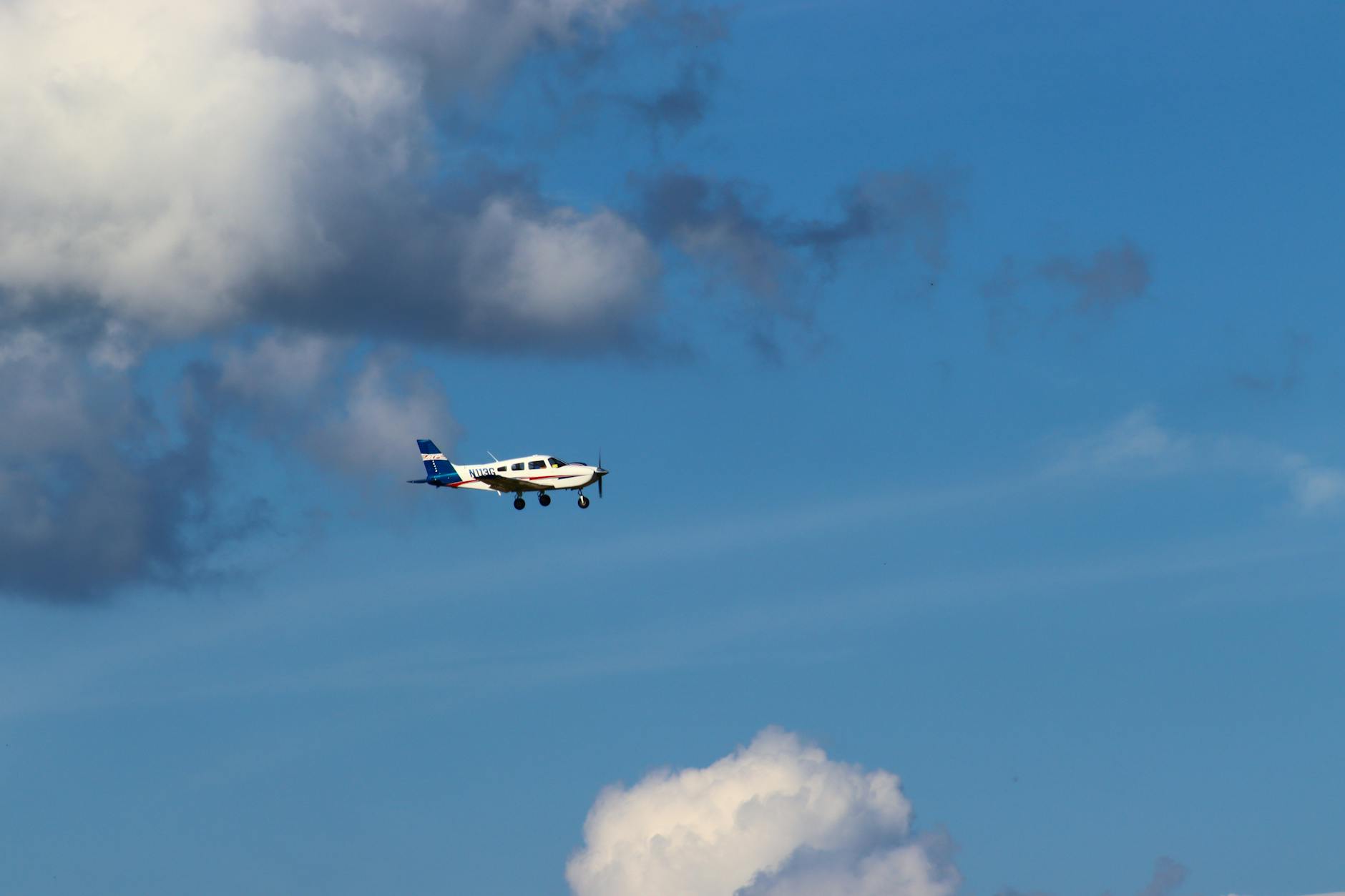 white and blue airplane in mid air under blue sky