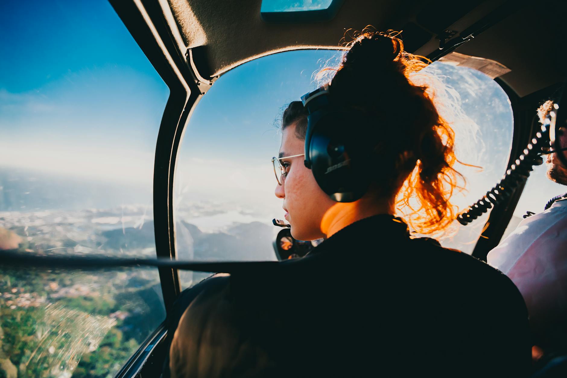 woman wearing headphones sitting inside a plane