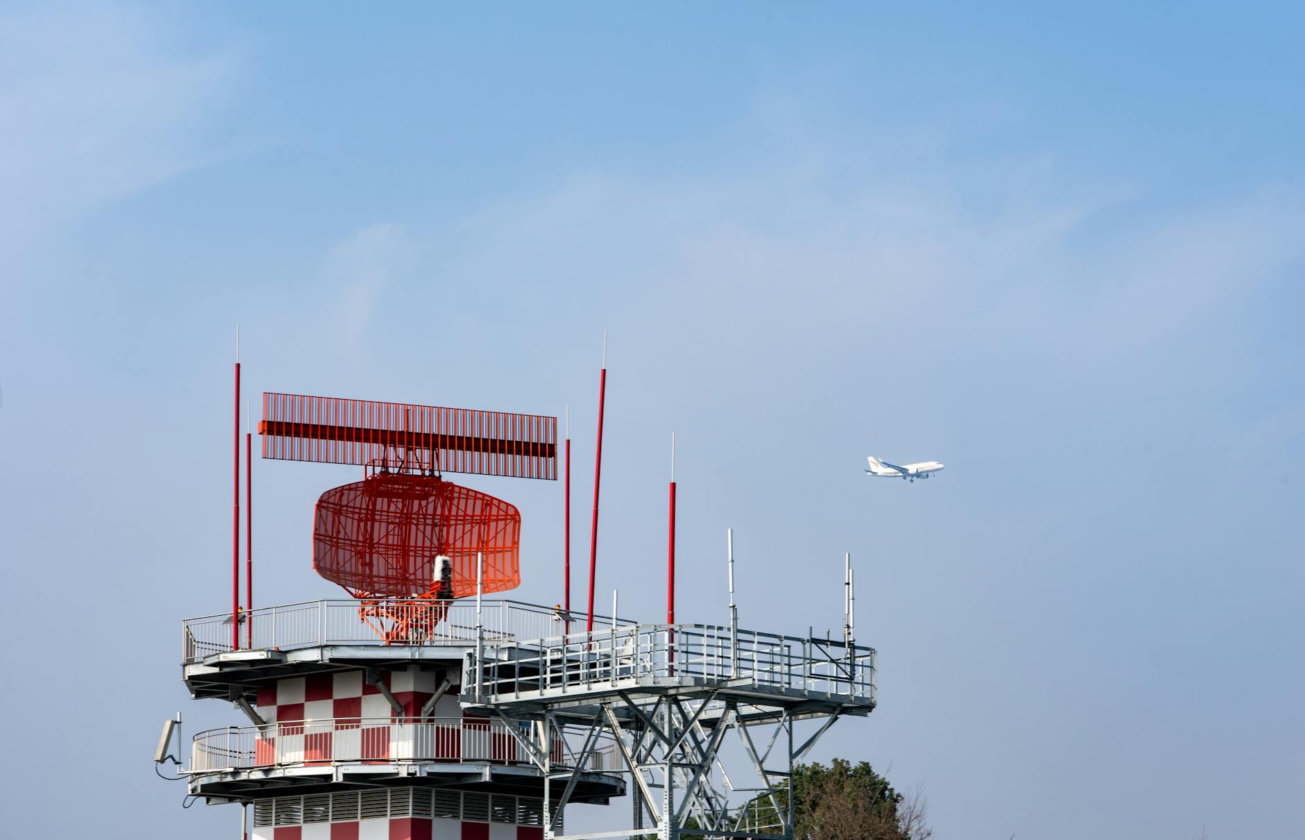 airport radar tower with airplane in sky