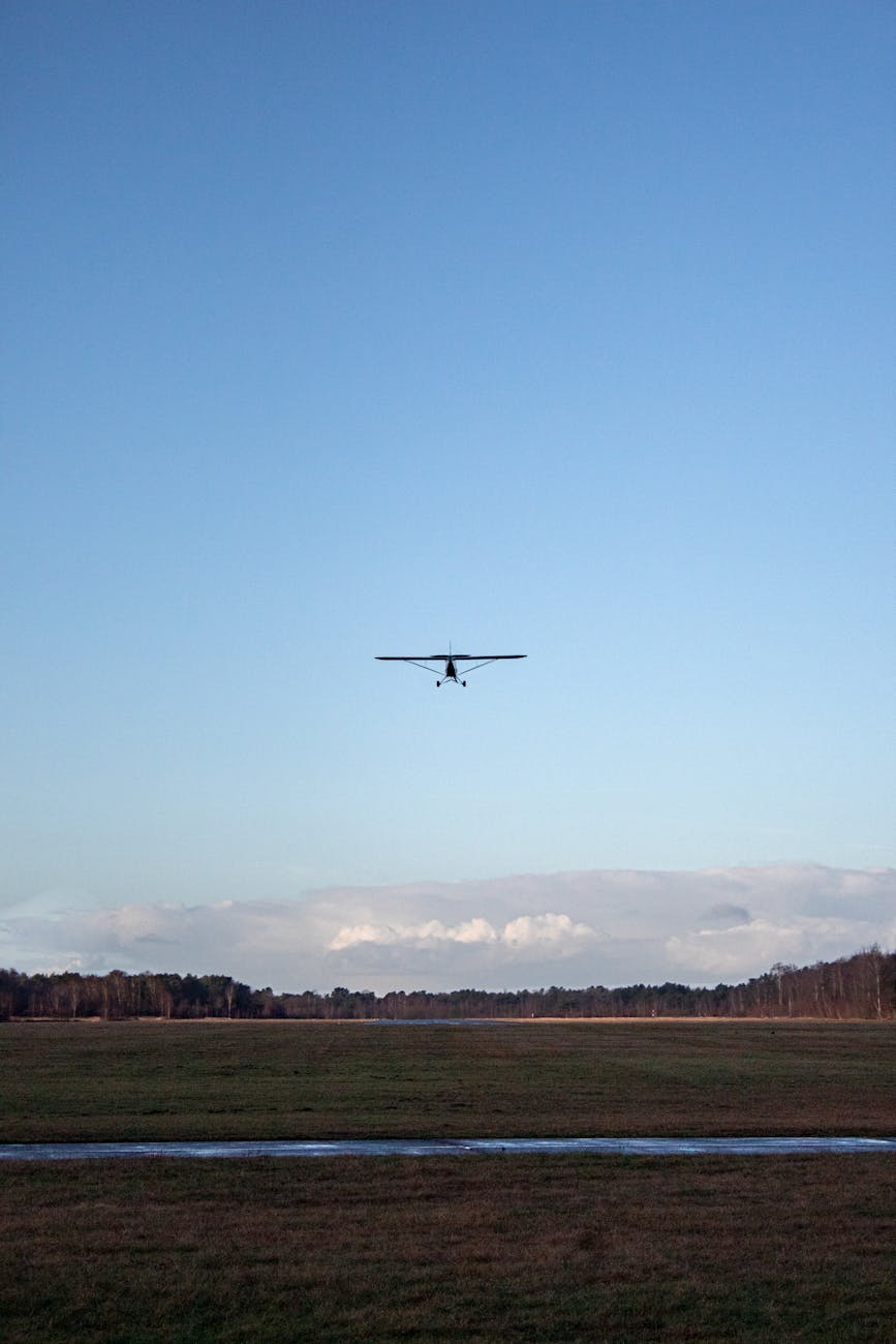 an airplane flying over an open field