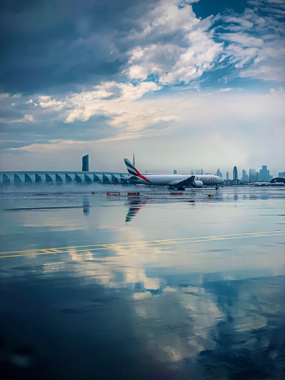 airplane on rainy runway with city skyline