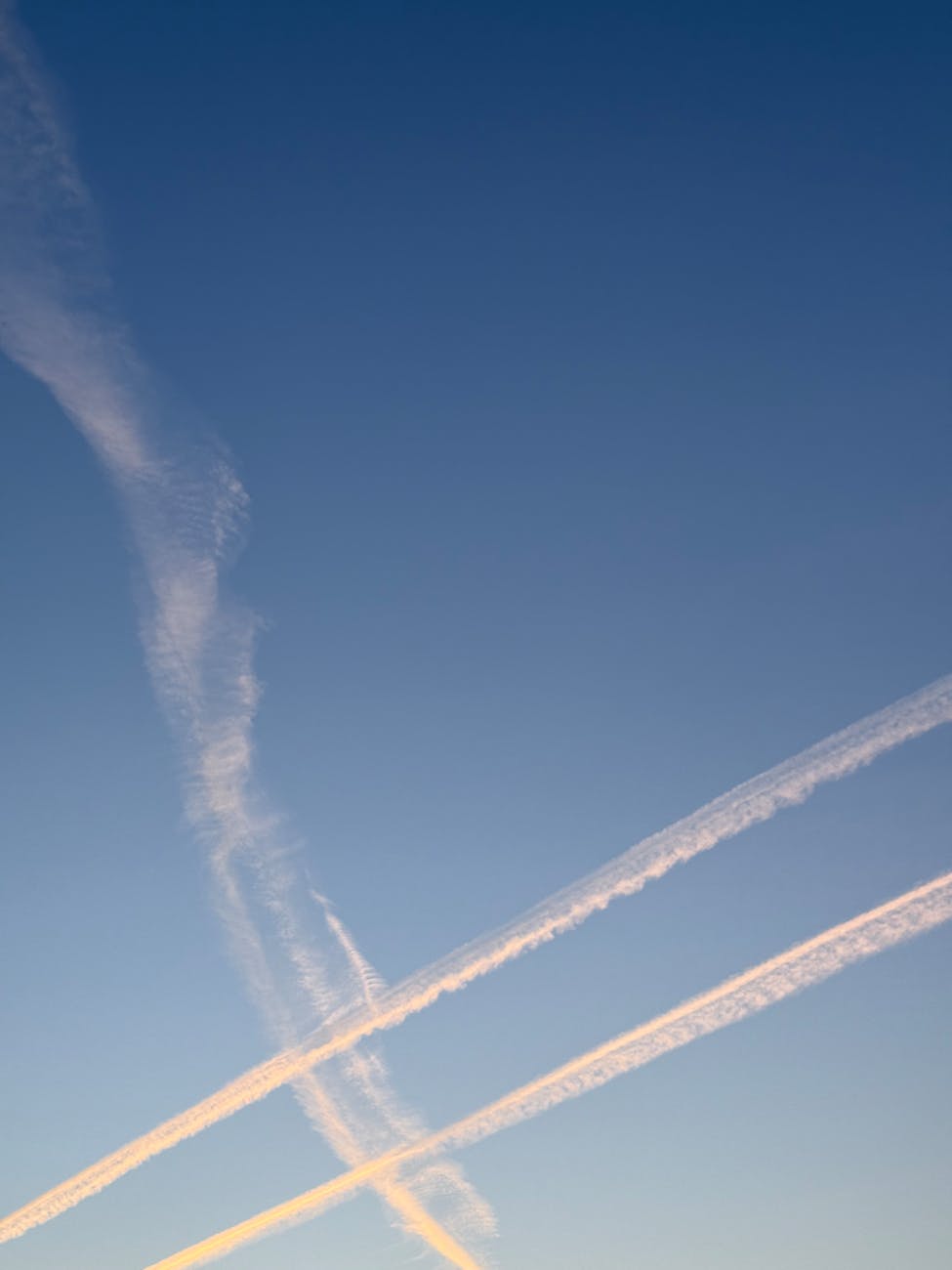 clear sky with contrails at sunset