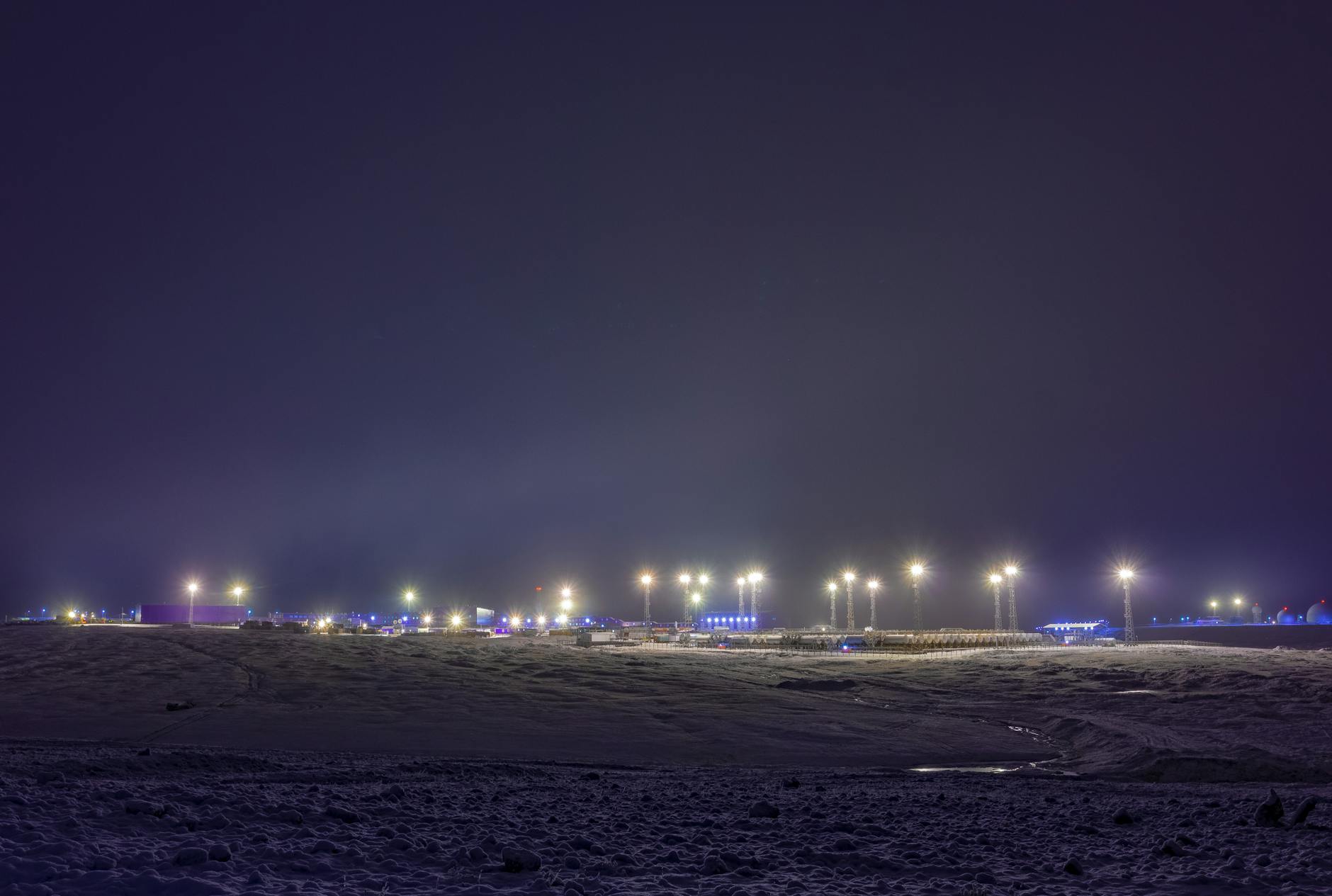a bare field with lights illuminated at night
