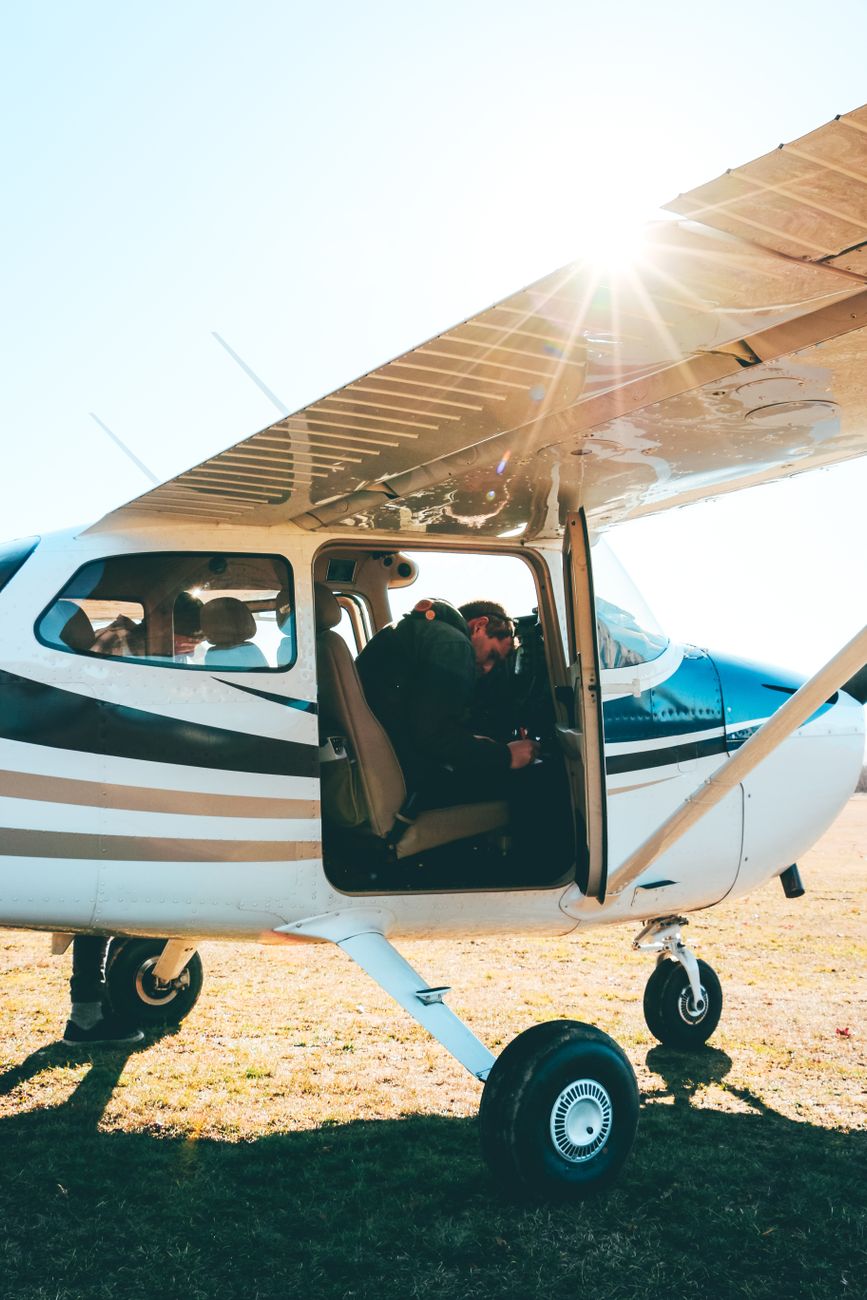 a man in black jacket sitting on white plane