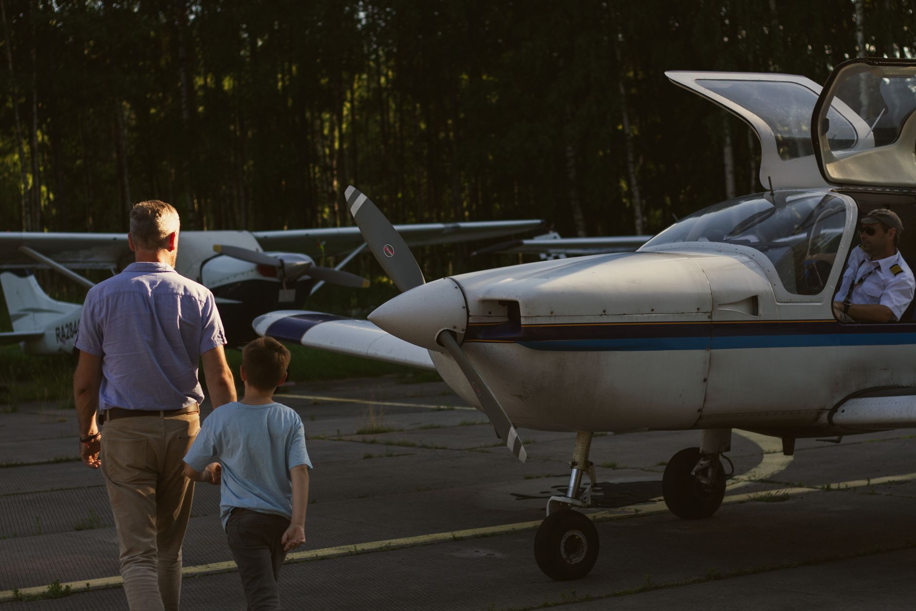 man and boy walking in front of airplane