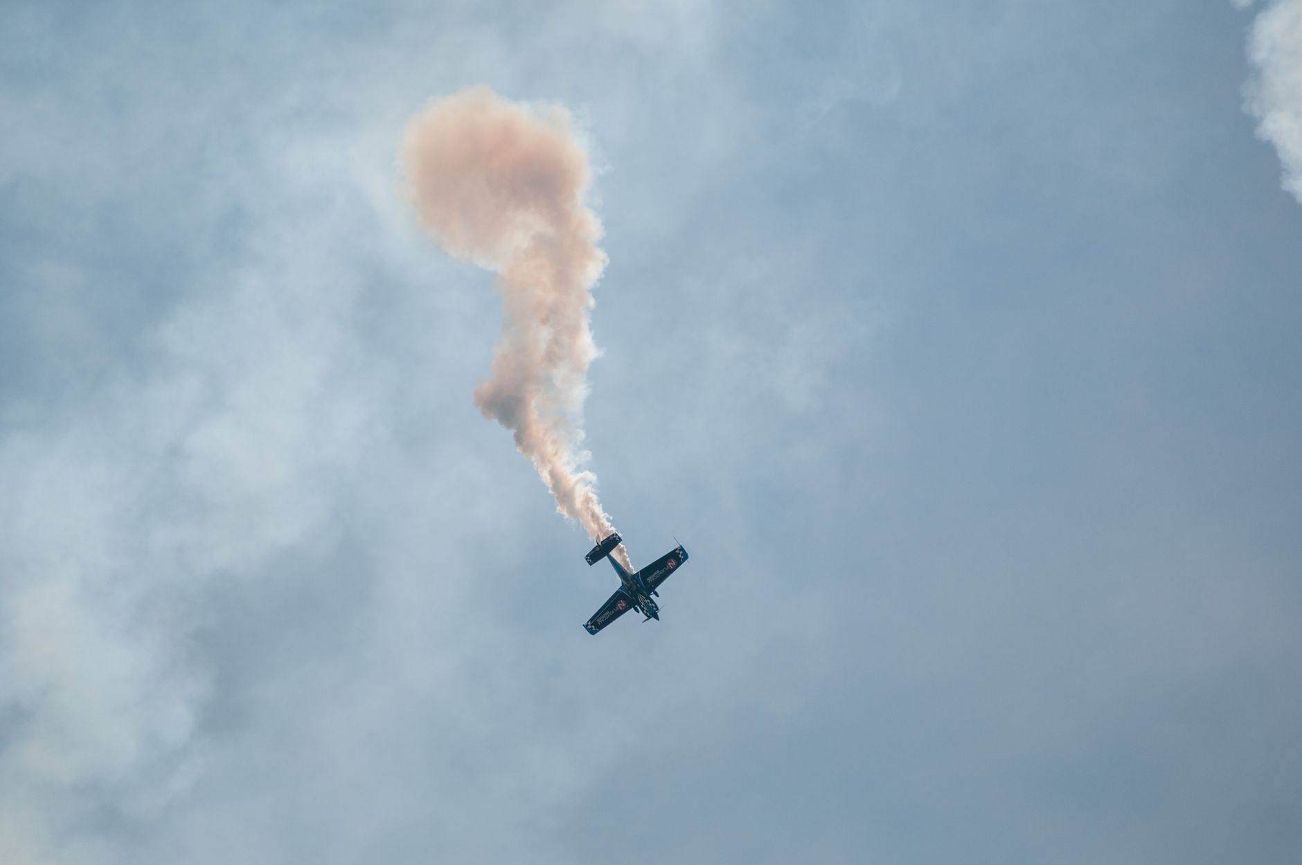 aerobatic airplane performing smoke trail stunt