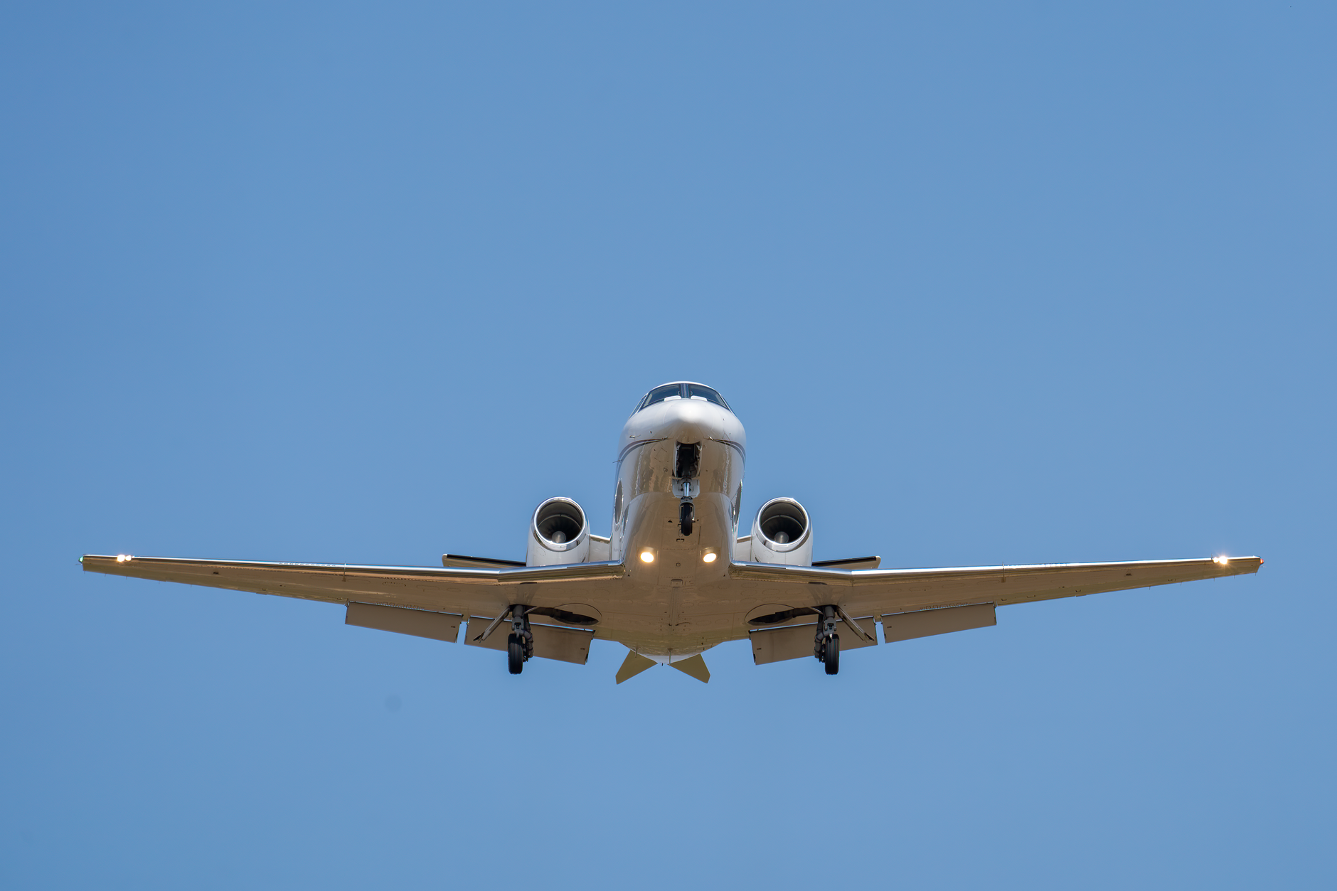 private jet flying overhead in clear sky