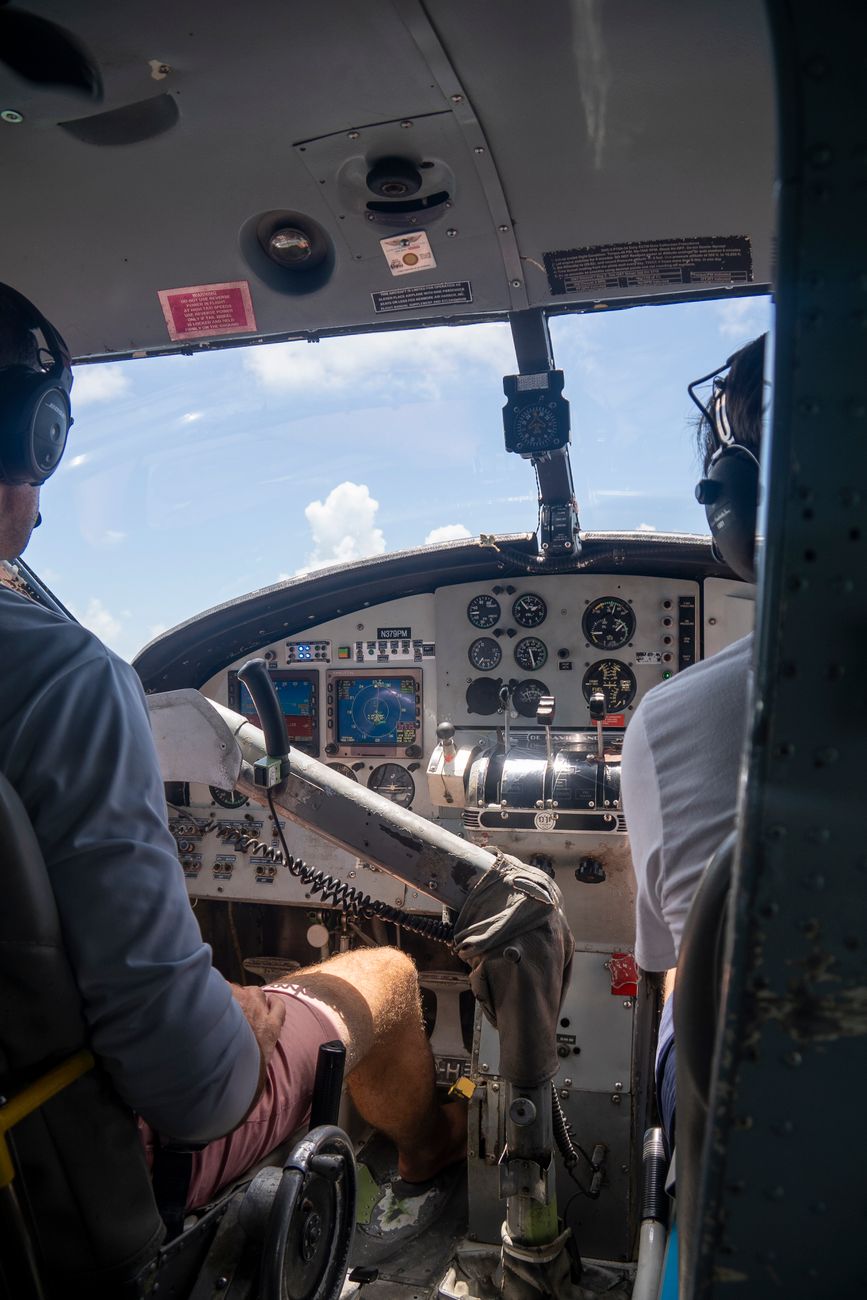two men sitting in the cockpit of a small plane