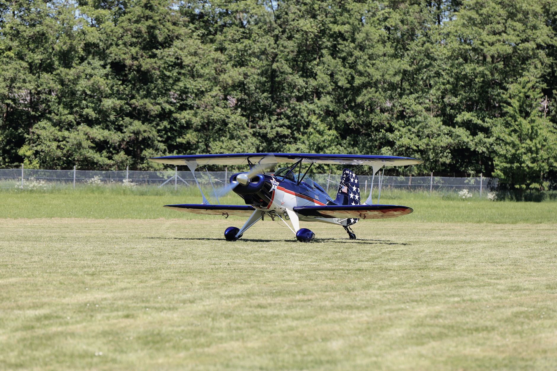 vintage biplane on grass runway at airfield